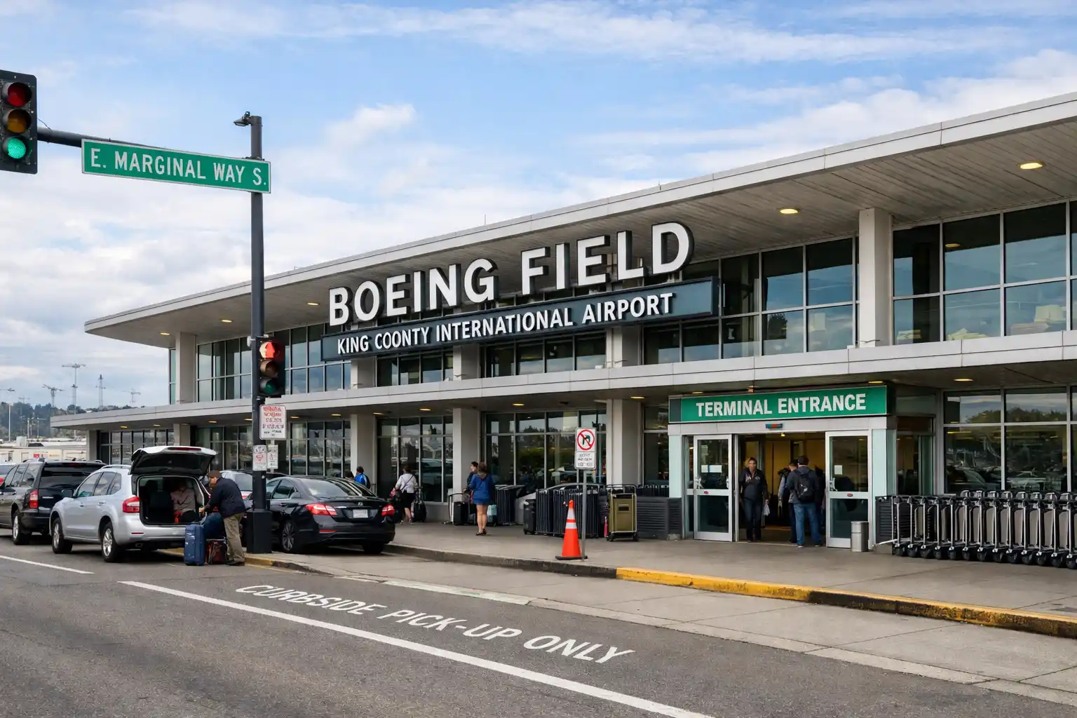 Boeing Field terminal curbside pickup zone with black town car waiting at passenger loading area on East Marginal Way South