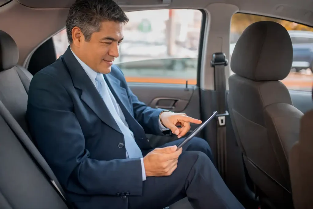 Professional town car driver reviewing fixed rate pricing on tablet in Seattle