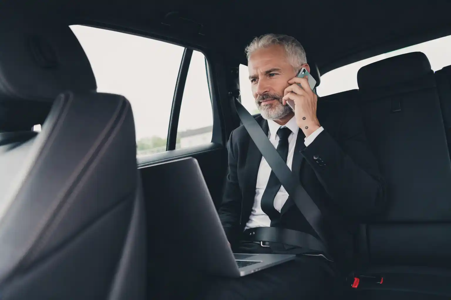 Business traveler working on laptop during ride to SeaTac Airport
