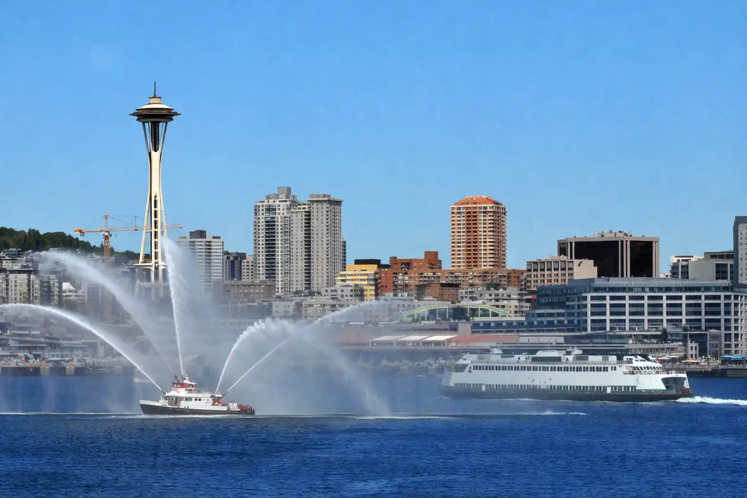 Seattle harbor cruise boat departing Pier 55 with downtown skyline and Space Needle view from Elliott Bay