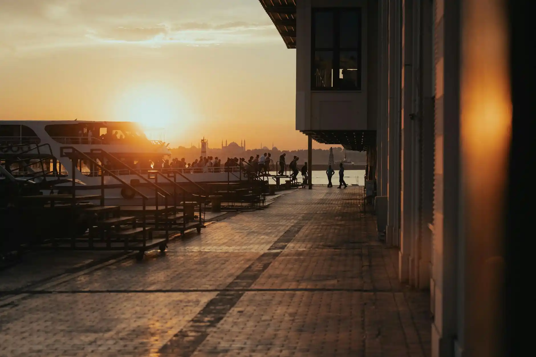 black luxury SUV parked near the Anacortes ferry terminal at sunrise, ferry boats in the background, travelers with rolling luggage, Pacific Northwest coastal atmosphere