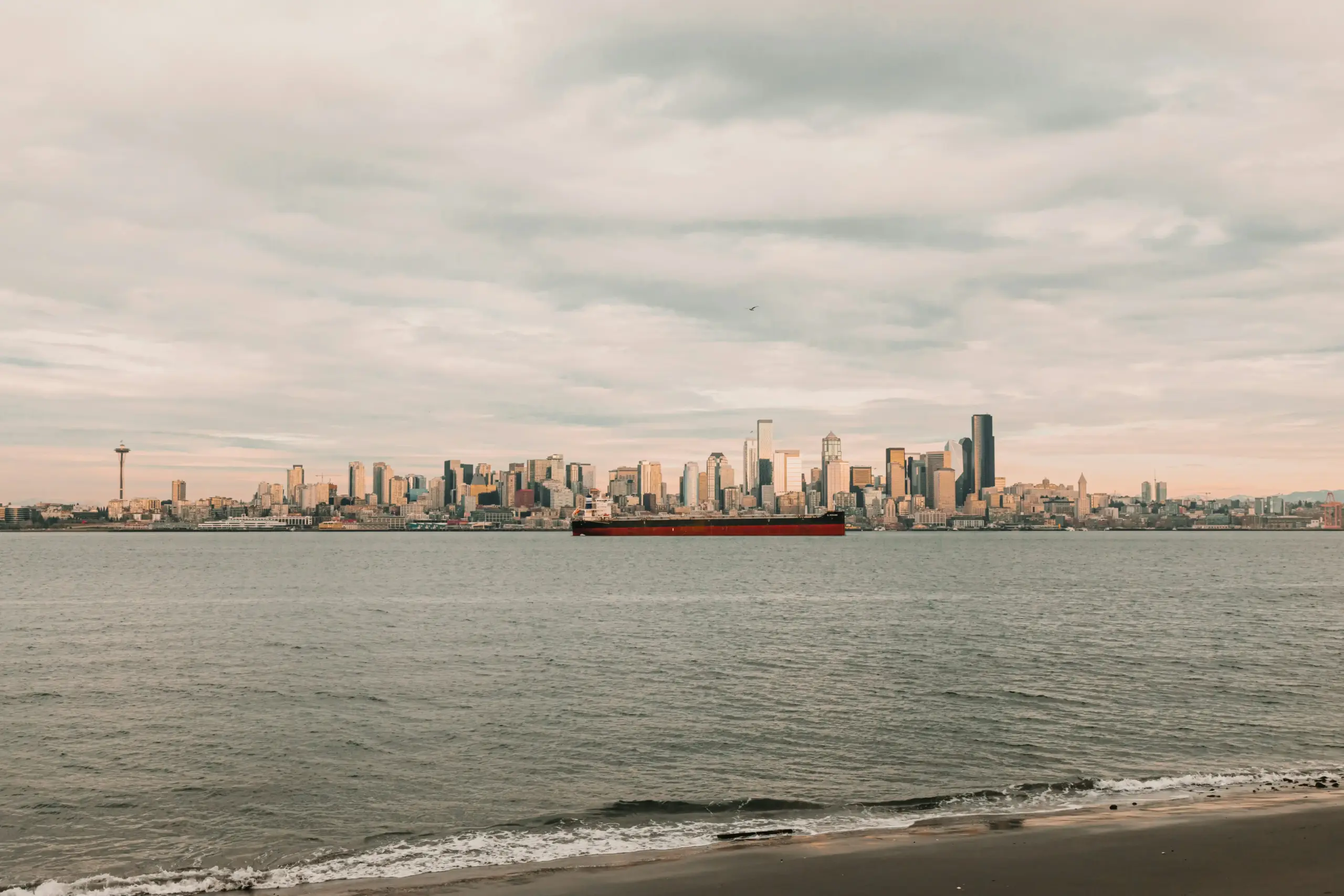 large passenger van with group of travelers loading suitcases outside waterfront hotel in Seattle