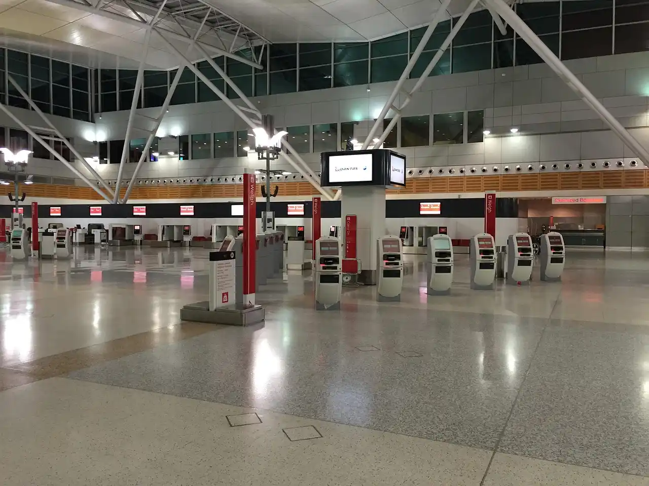 Sea-Tac international arrivals exit area with travelers, chauffeur holding sign, luggage carts and signage visible