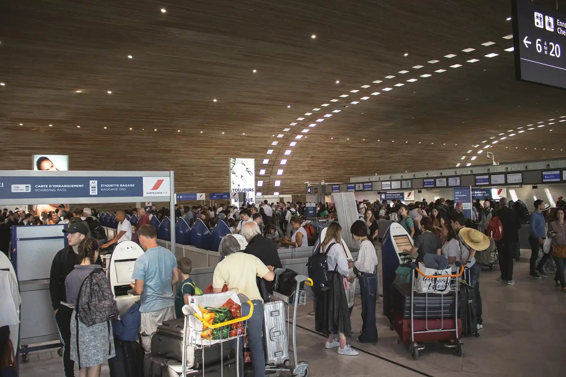 family with children and multiple suitcases being assisted by a chauffeur at airport arrivals with warm lighting and modern terminal design