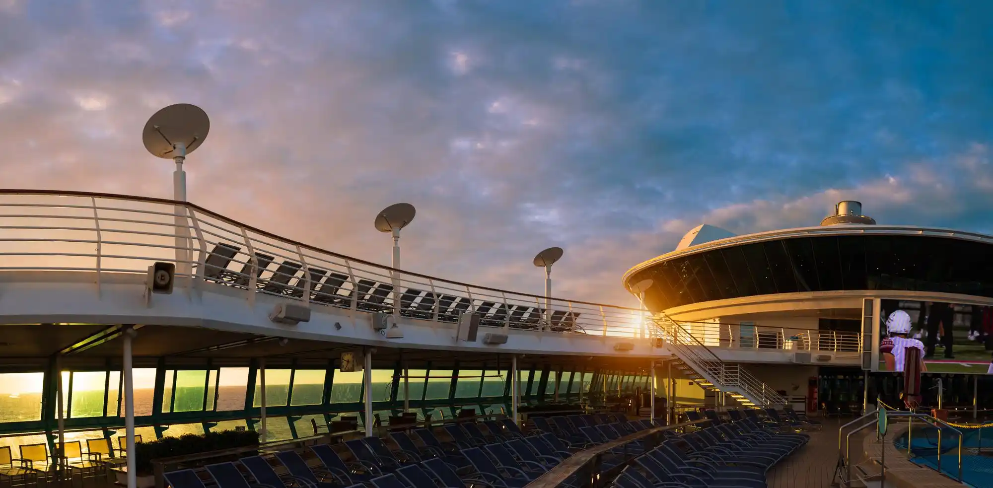 black luxury SUV dropping off cruise passengers with rolling luggage outside Seattle Pier 66 on a bright summer morning, waterfront skyline and ferry in the background
