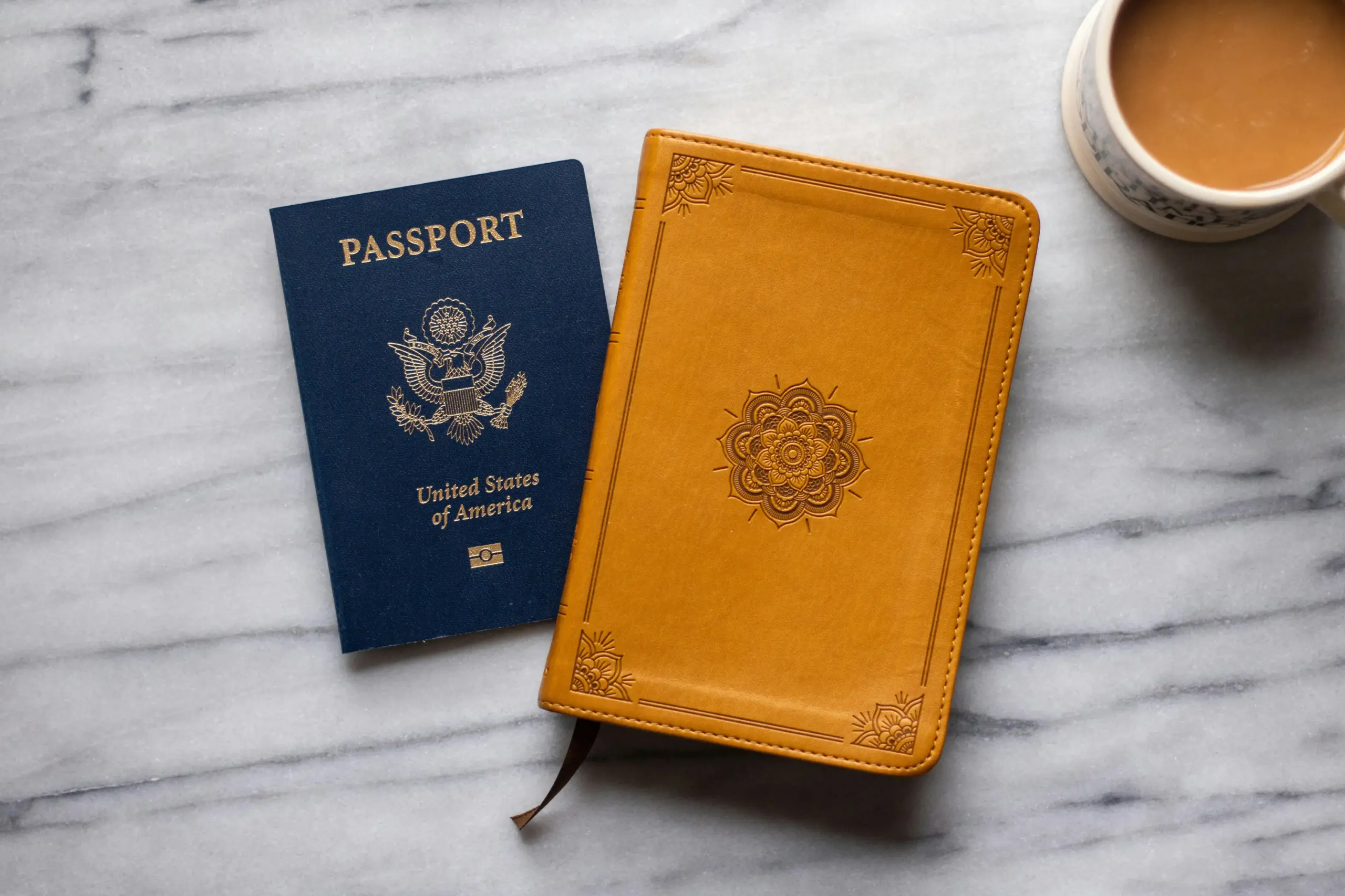close-up of traveler booking executive airport transfer on smartphone with YVR flight details visible, coffee cup and passport on table, modern hotel lobby background