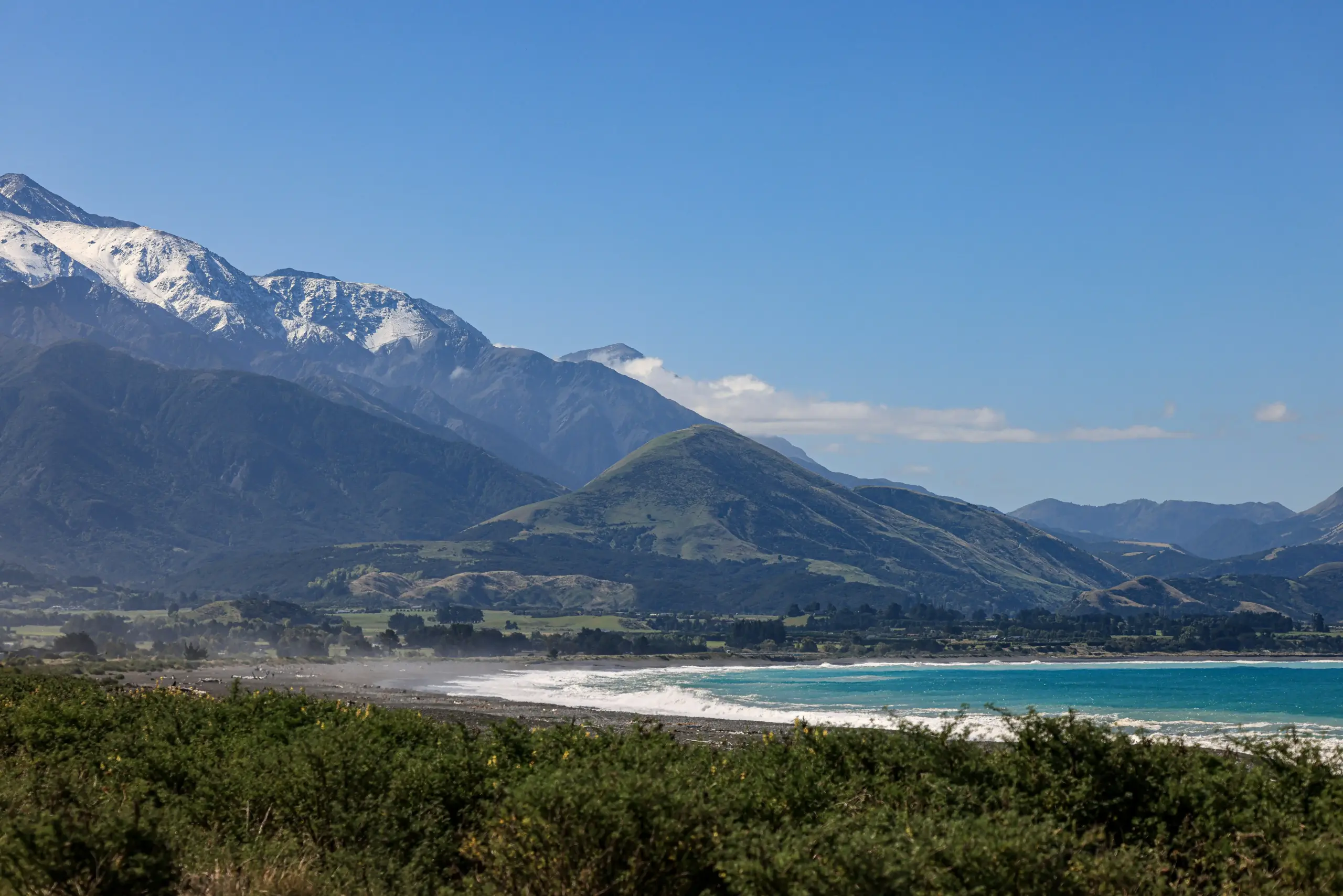 luxury black SUV driving along a scenic coastal highway with snow-capped mountains and evergreen forests, Sea-to-Sky Highway atmosphere