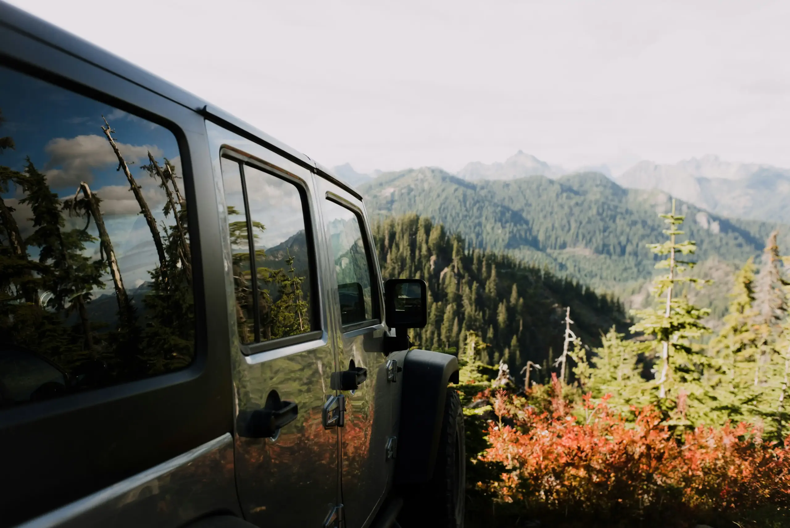luxury black SUV parked outside a modern Woodinville winery with vineyard rows, autumn light, tasting guests in smart casual attire, Pacific Northwest scenery