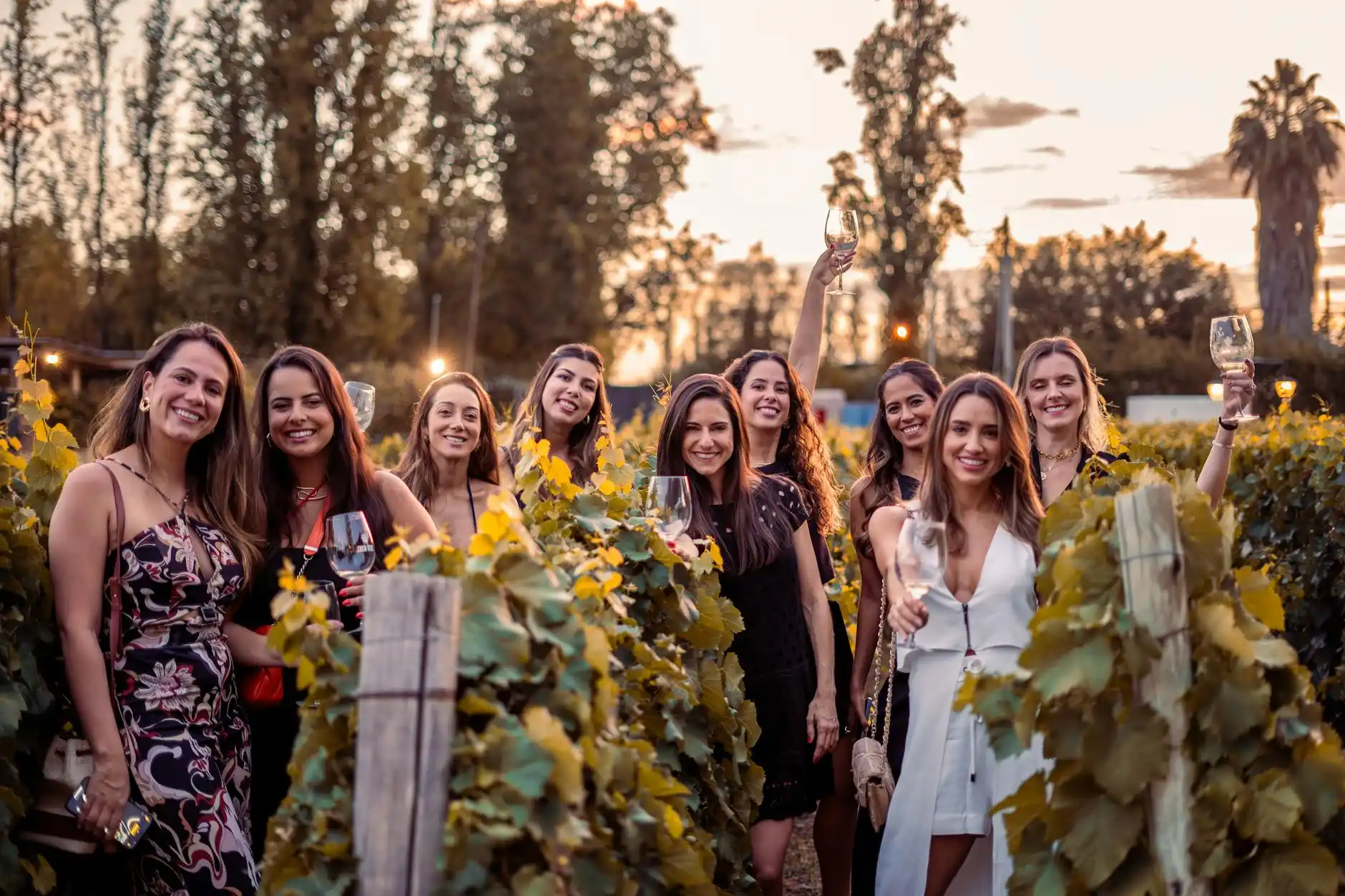 group of friends enjoying wine tasting at a modern Woodinville winery patio with string lights and vineyard backdrop