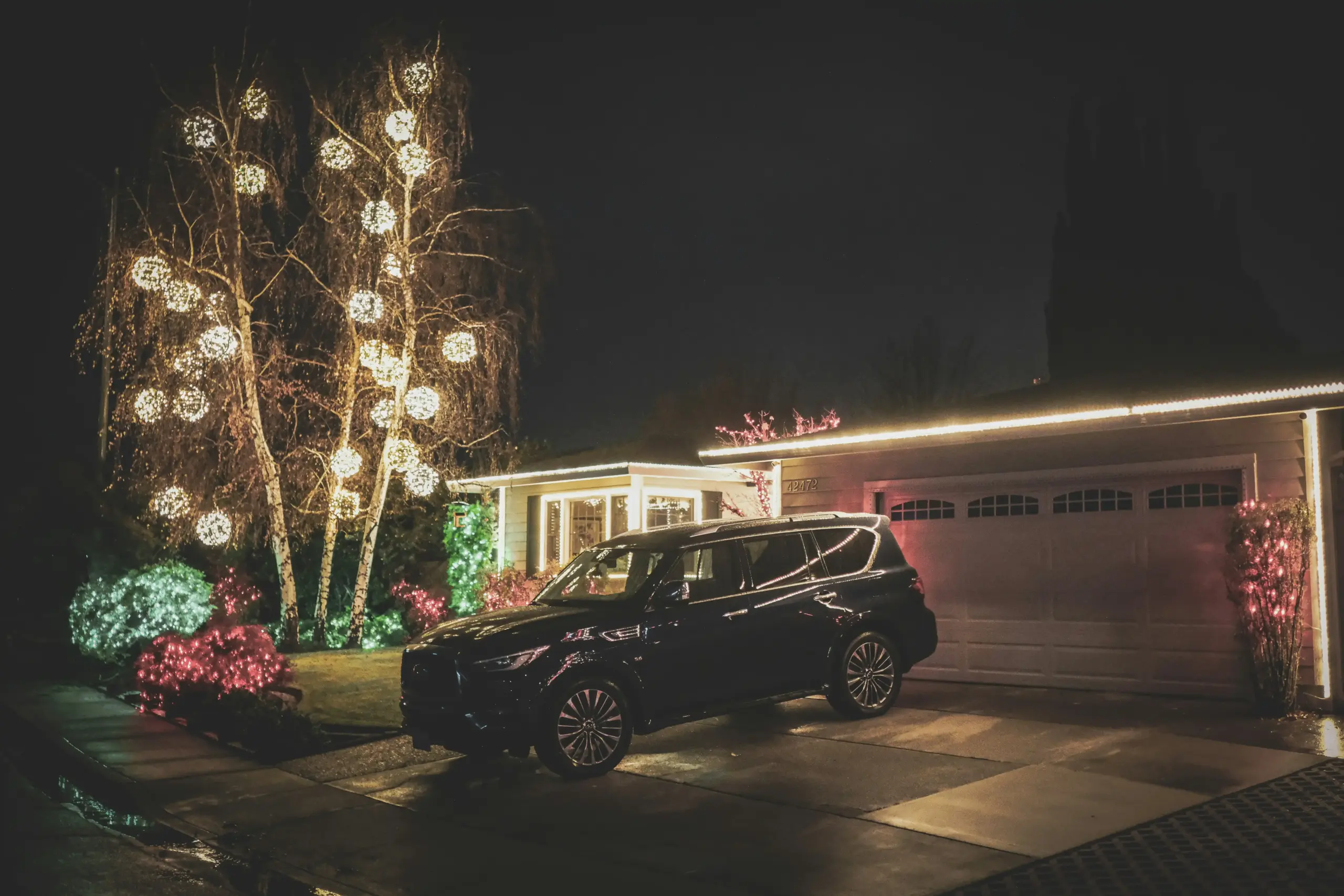 luxury black SUV parked outside a modern winery entrance with guests stepping out dressed for a wine tour
