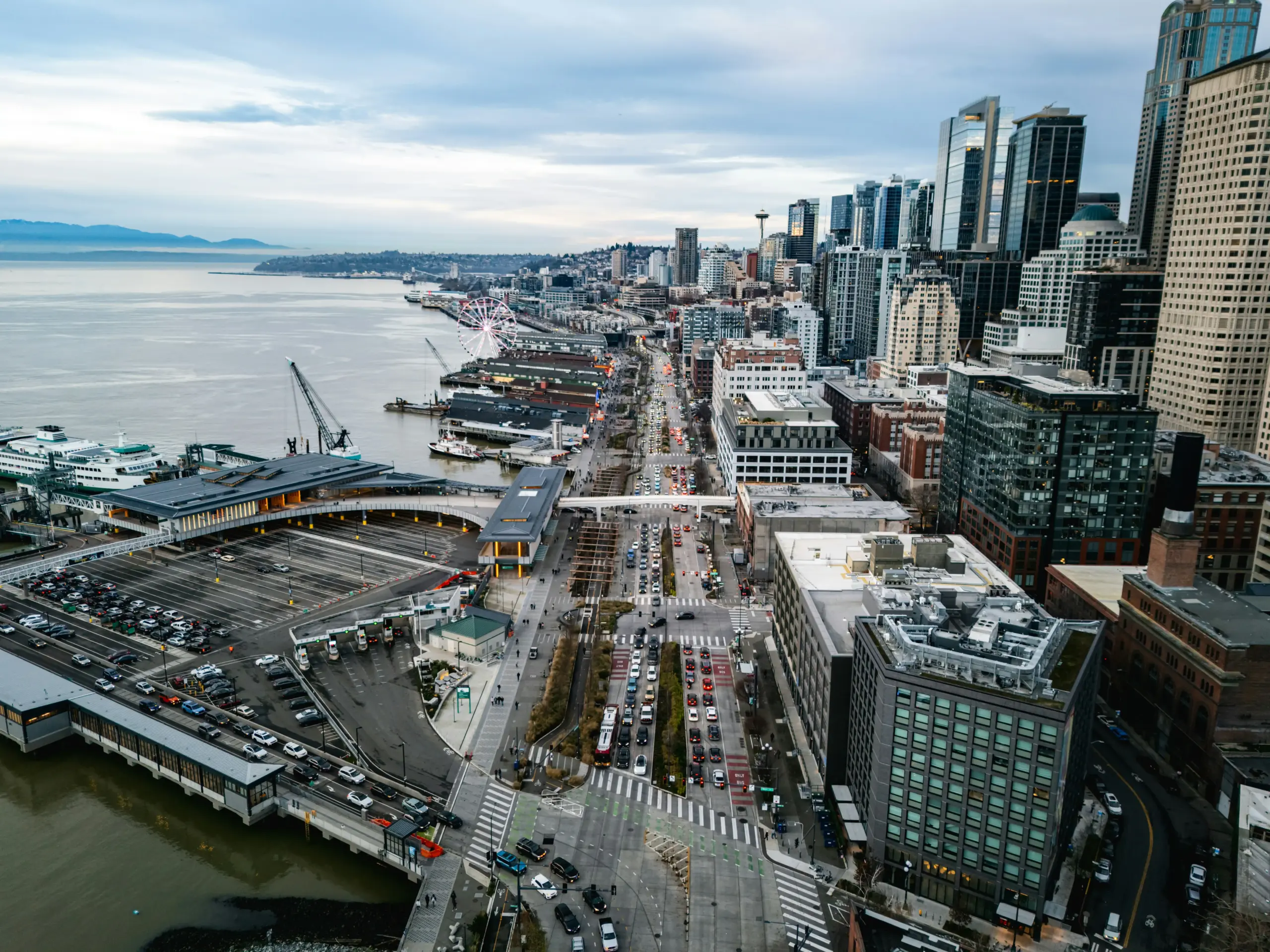 aerial-style view of Seattle traffic routes connecting a private airport terminal to downtown hotels, Bellevue offices, and waterfront residences, overcast Pacific Northwest light