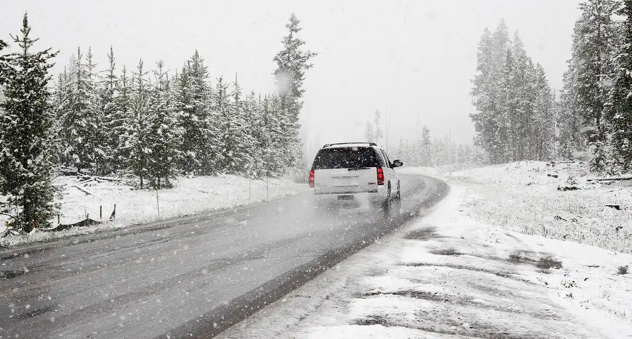 luxury black SUV parked at a scenic overlook on Highway 2 with snow-capped Cascade Mountains in the background, travelers loading luggage for a Leavenworth trip, bright winter m...