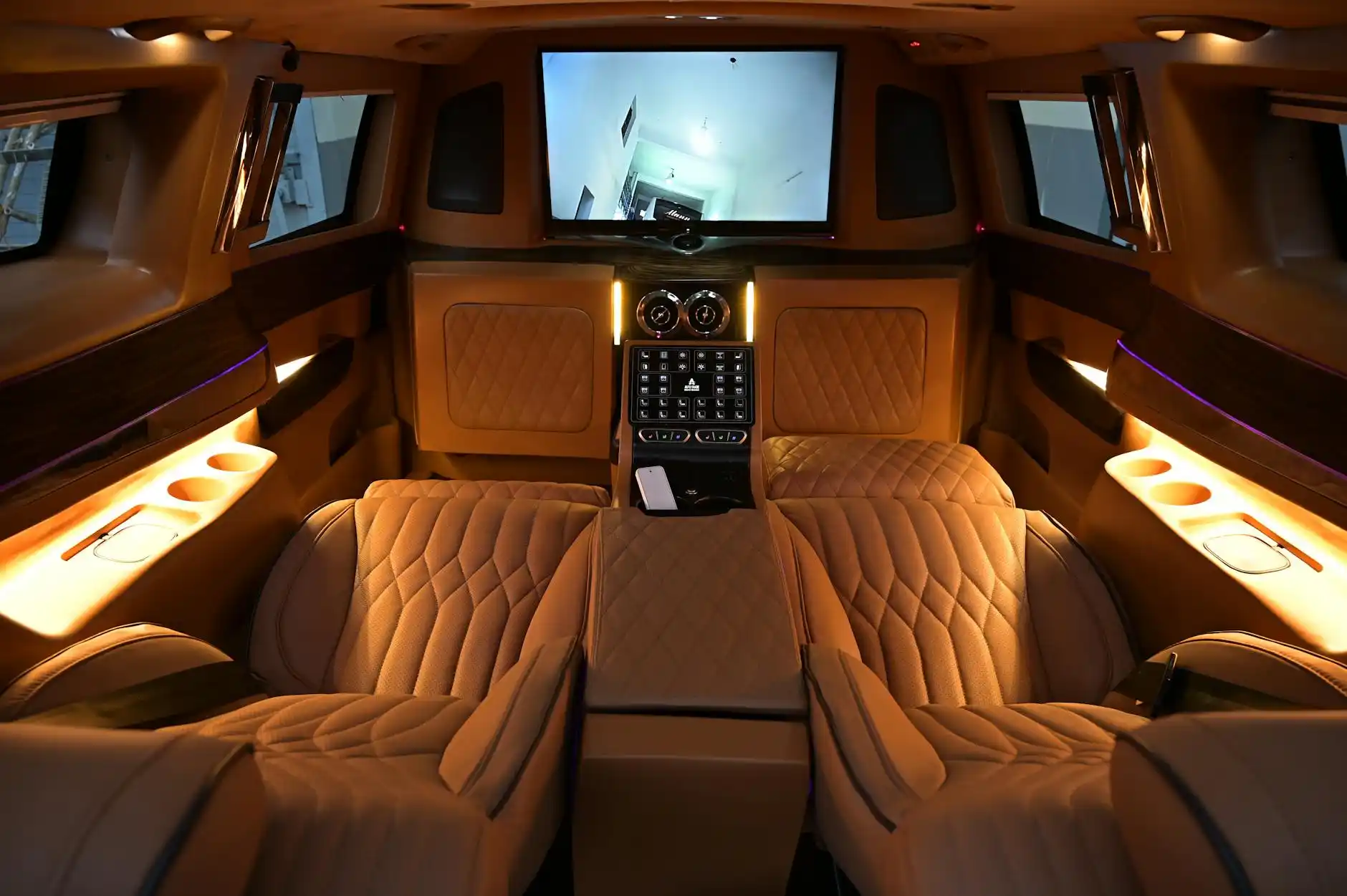 luxury Mercedes Sprinter interior with leather captain seats, overhead lighting, ski bags neatly stored, winter resort travelers seated comfortably