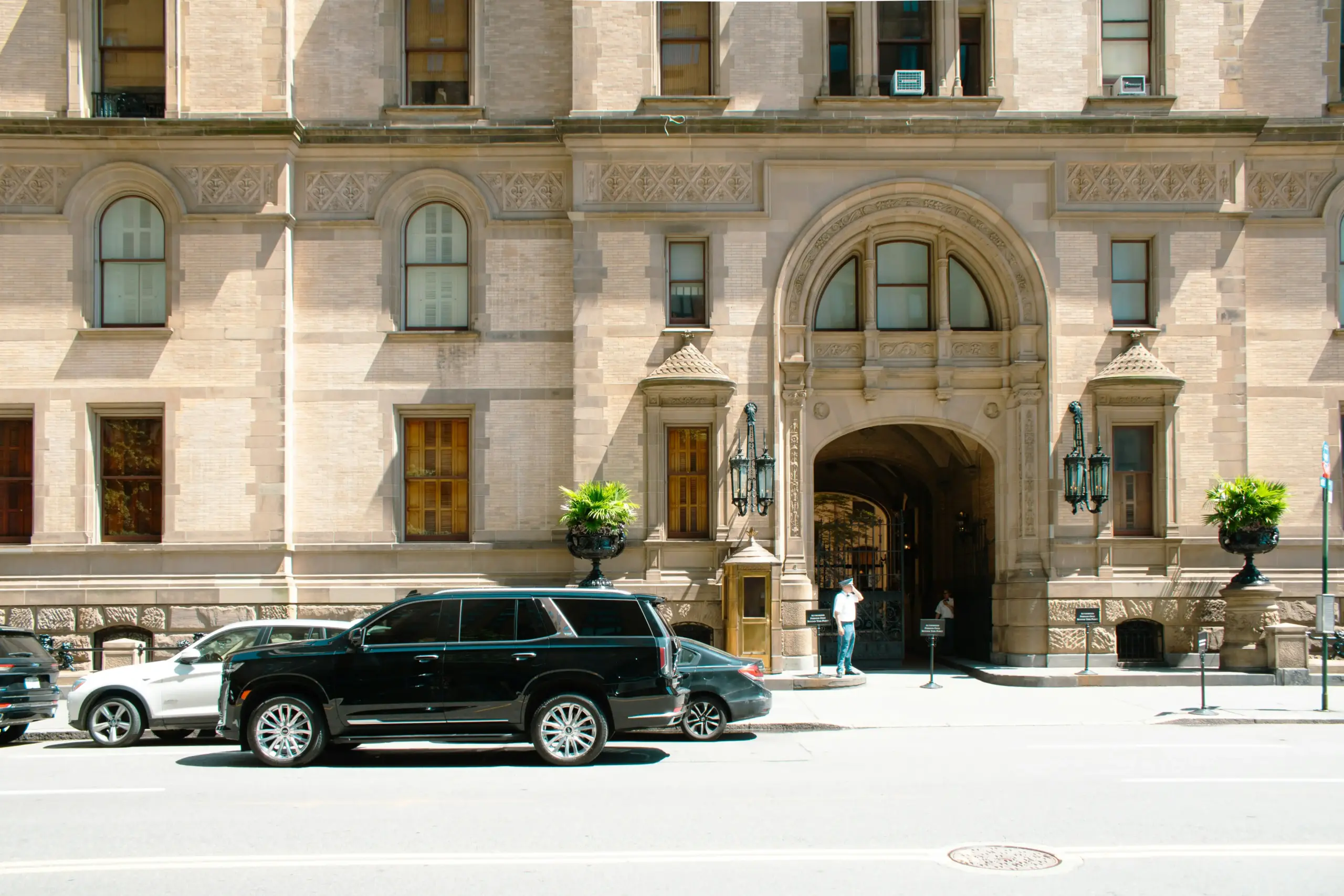 luxury black SUV parked outside a downtown Seattle hotel at sunrise, luggage and ski bags neatly loaded, city skyline and wet pavement reflecting morning light