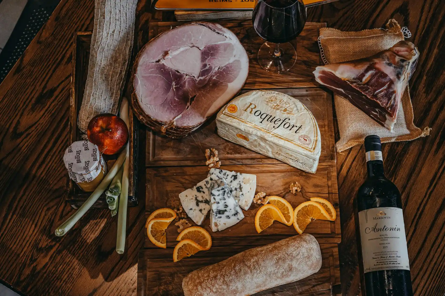 elegant winery lunch setting with charcuterie boards, plated seasonal dishes, wine glasses, and a chauffeur waiting discreetly beside a black luxury vehicle outside