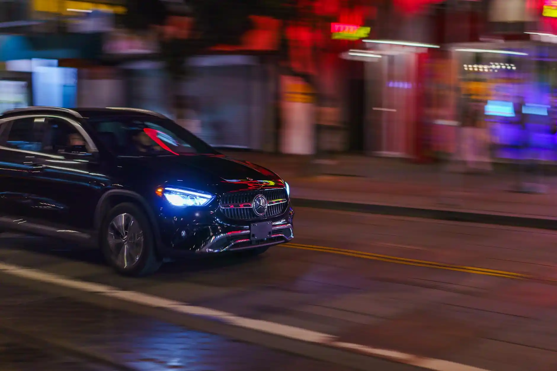 elegant nighttime airport departure scene at Sea-Tac with black luxury SUV, chauffeur opening rear door for couple with premium luggage, terminal lights glowing in the background
