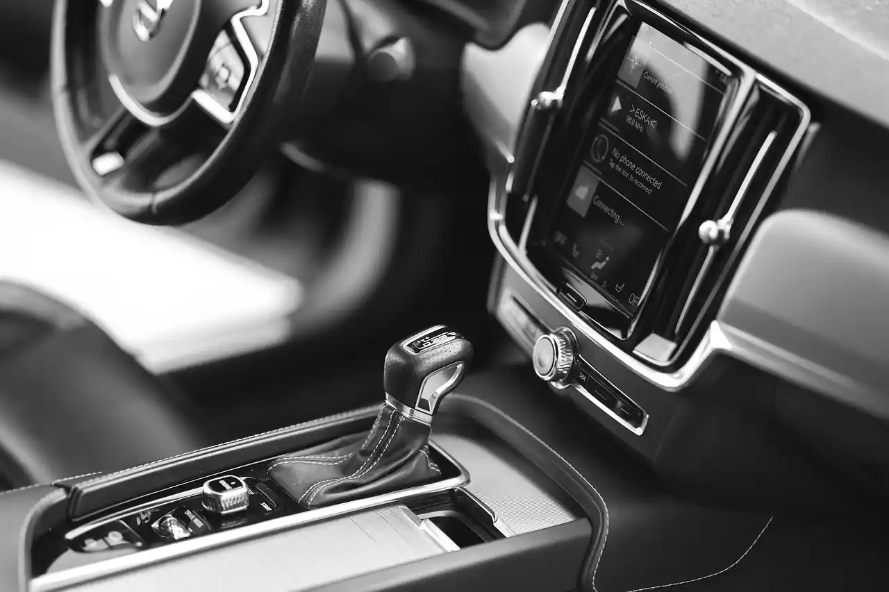 interior of a luxury black sedan with beige leather seats, soft ambient lighting, bottled water in center console, Seattle skyline blurred through rain-speckled windows