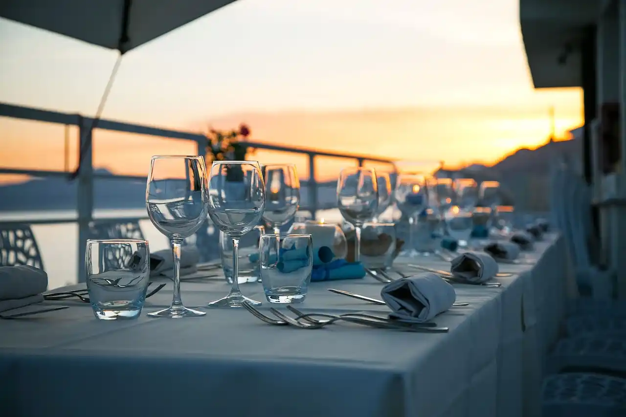 sophisticated anniversary table at Seattle fine dining restaurant with candlelight, white floral arrangement, waterfront window view, and a luxury SUV waiting outside