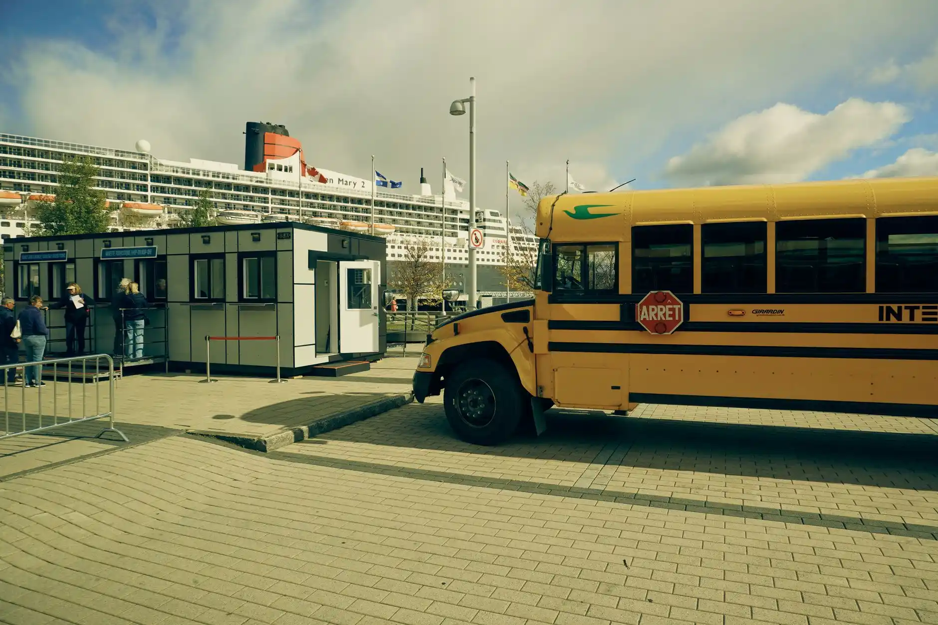 busy Seattle cruise terminal curbside on embarkation day with organized chauffeur pickup, porters handling tagged luggage, large Alaska-bound cruise ship boarding in background