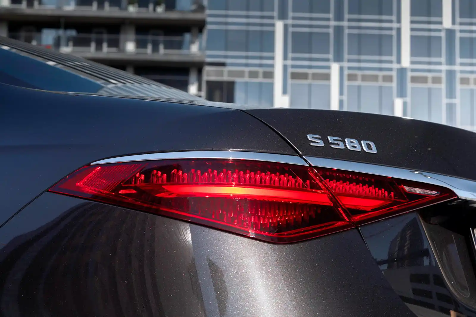 black luxury SUV parked outside Seattle Boeing Field terminal at golden hour, professional chauffeur opening the rear door, travelers with rolling luggage preparing for a cross-...