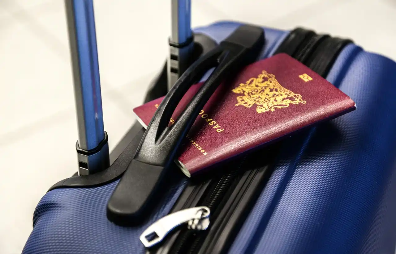 close-up of traveler hands holding passports, flight itinerary, and smartphone map beside neatly packed suitcases in an executive airport pickup setting