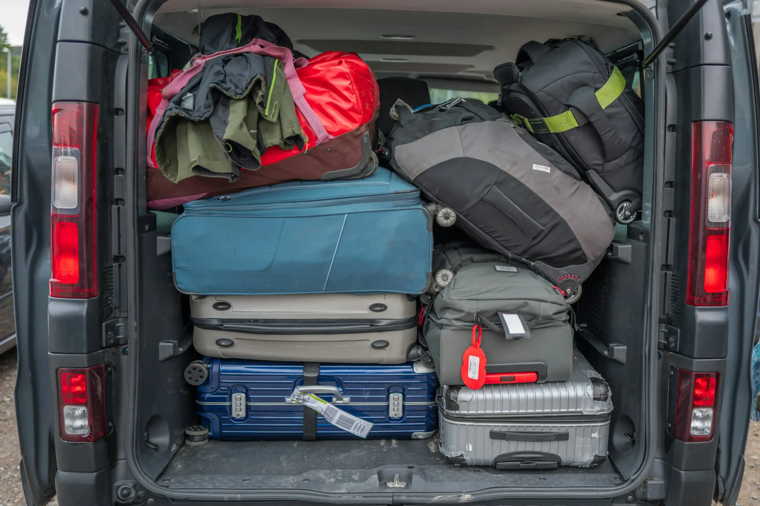 luxury van loading luggage outside an upscale downtown Seattle hotel, concierge assisting international travelers bound for Vancouver cruise terminal