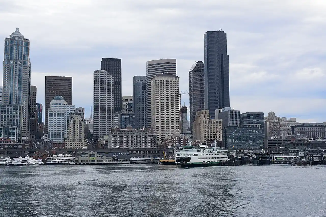 split-scene of three Seattle wedding venue styles, luxury downtown hotel entrance, waterfront ceremony deck with Elliott Bay views, and private estate with tree-lined driveway