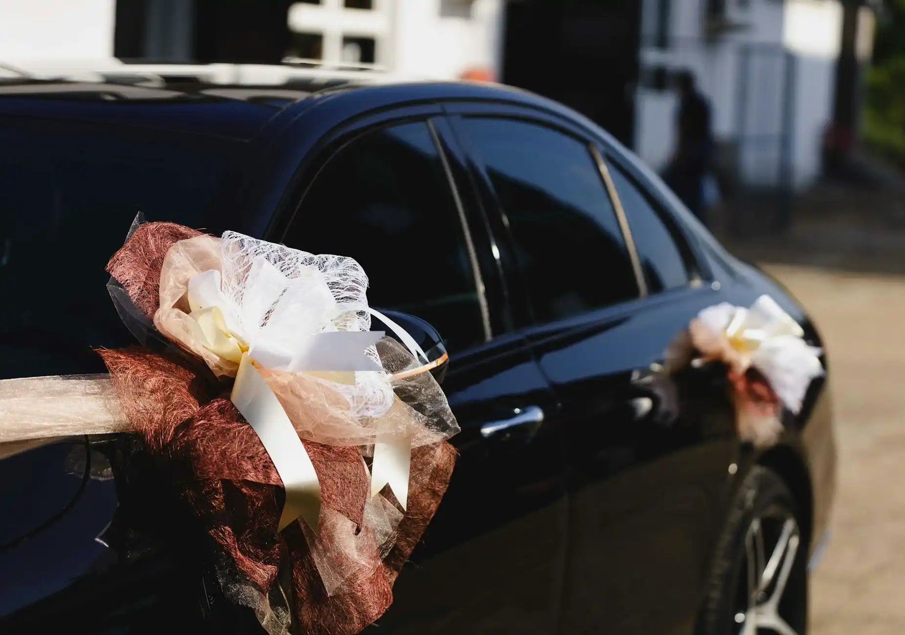 wedding planner reviewing a Seattle wedding transportation timeline on a clipboard beside a black executive sedan, bridal bouquet and city map visible, sophisticated planning scene