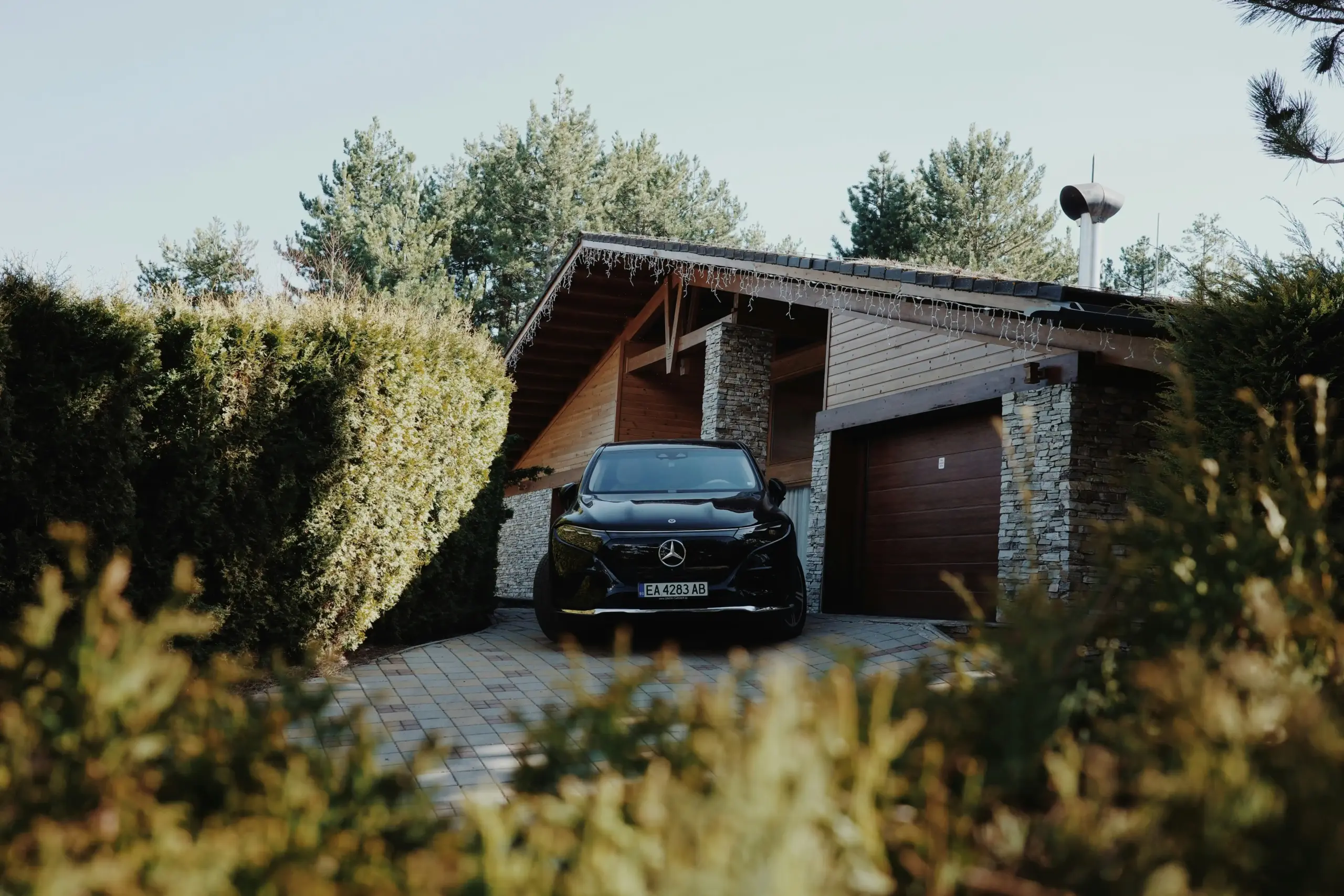 side-by-side visual of a black luxury SUV, executive passenger van, and sleek town car lined up near a Pacific Northwest winery driveway with autumn trees