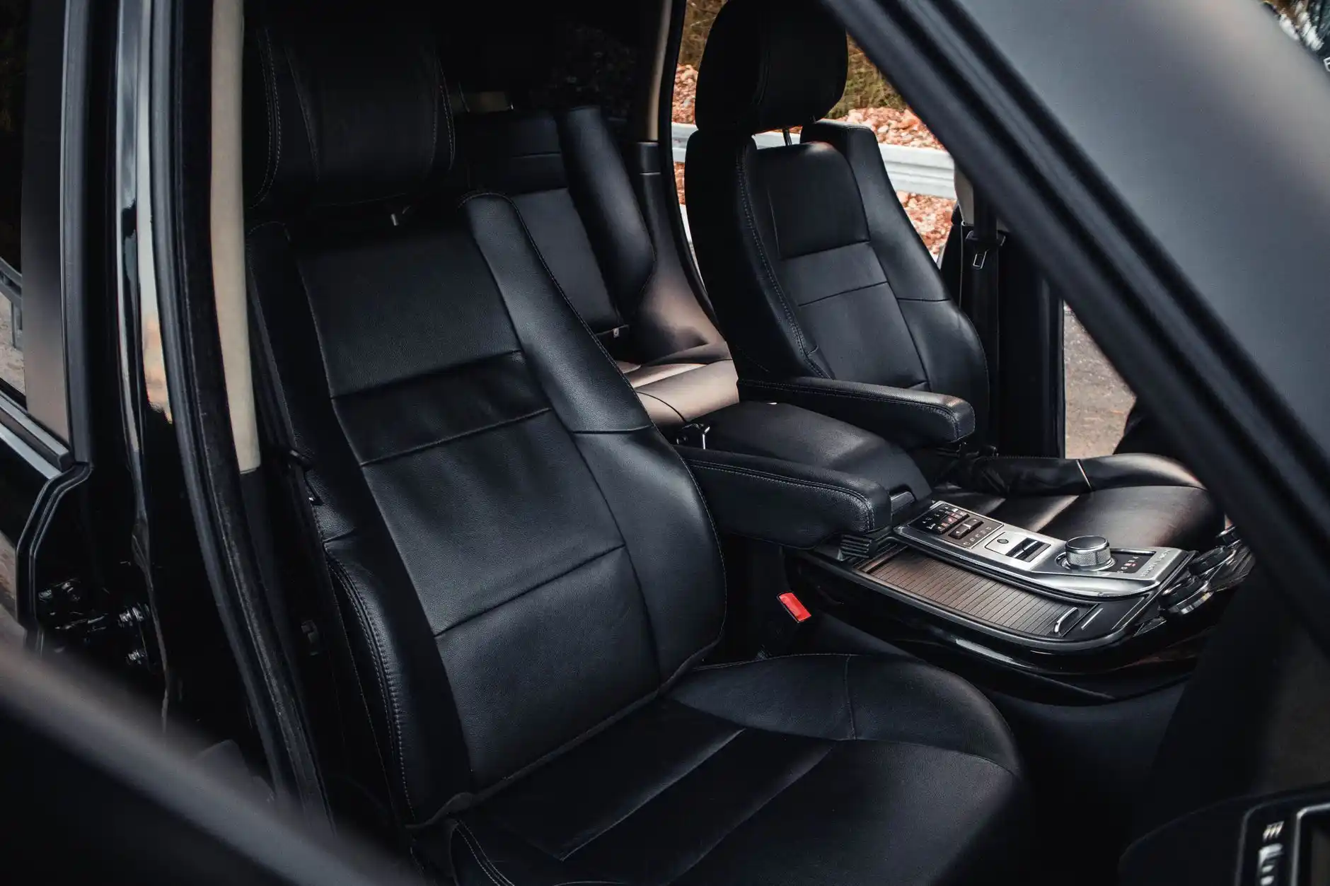 spacious luxury SUV interior with captain seats, carry-on bags and large suitcases neatly loaded, Seattle skyline visible through windshield