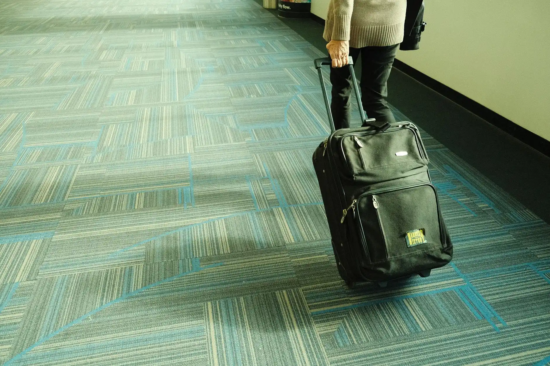 Professional chauffeur beside a black SUV at Seattle-Tacoma International Airport, assisting a family with multiple suitcases near the departures entrance