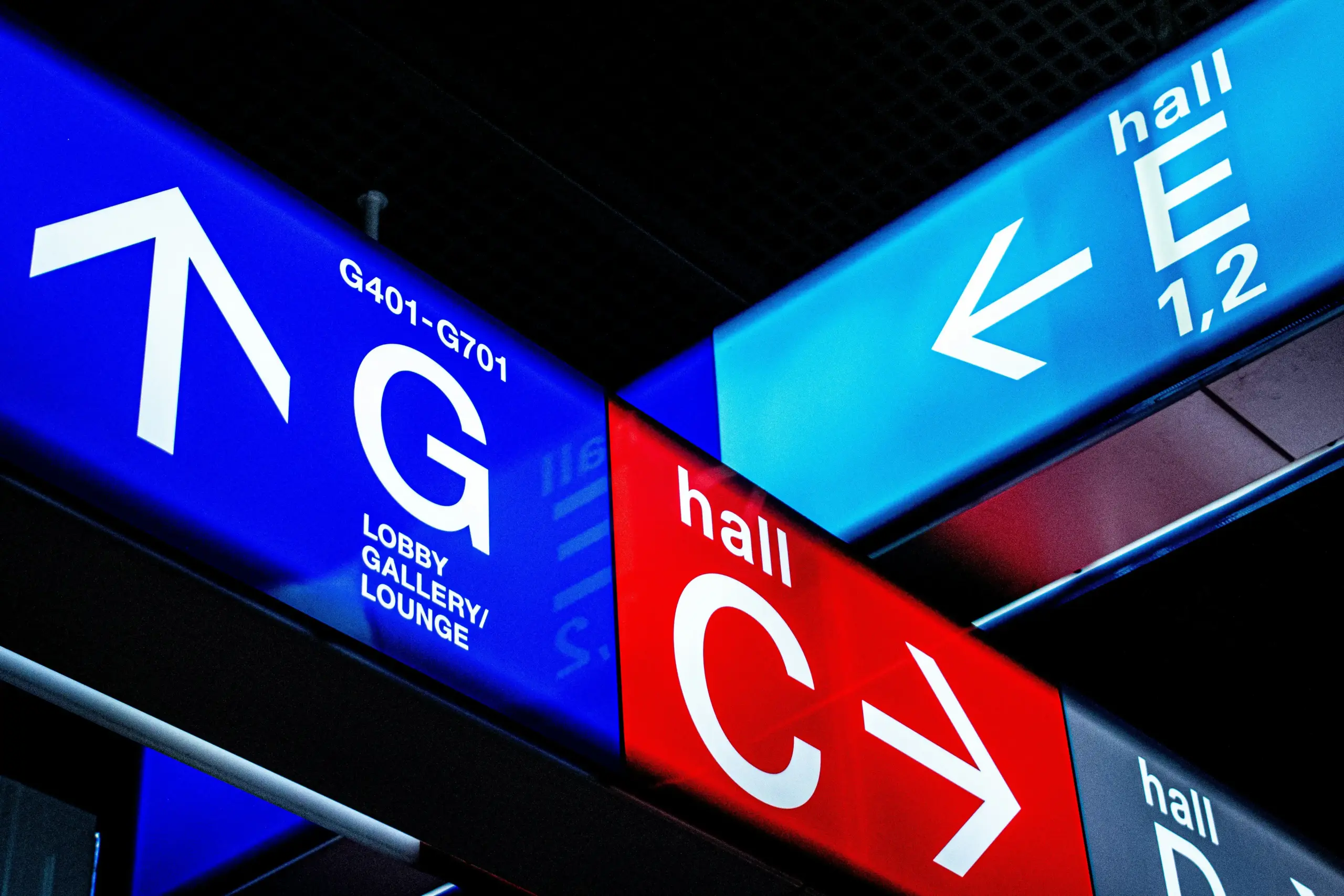 Seattle-Tacoma International Airport arrivals area showing signs directing travelers toward Link light rail, taxis, rideshare pickup, and prearranged car service