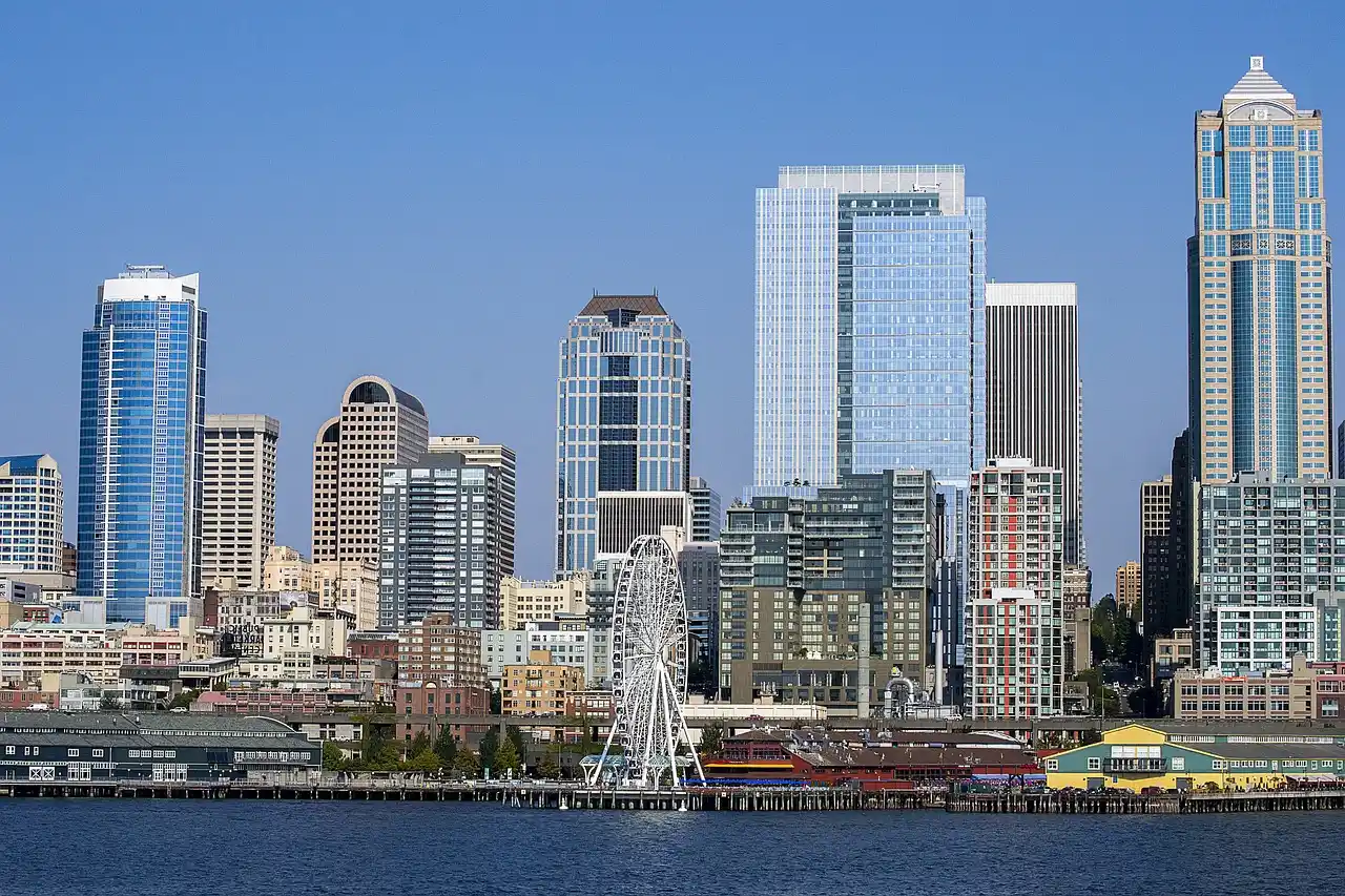 side-by-side map style visual of Seattle cruise terminals showing SeaTac Airport route to Pier 66 downtown waterfront and Pier 91 Smith Cove with labeled travel times and luggag...