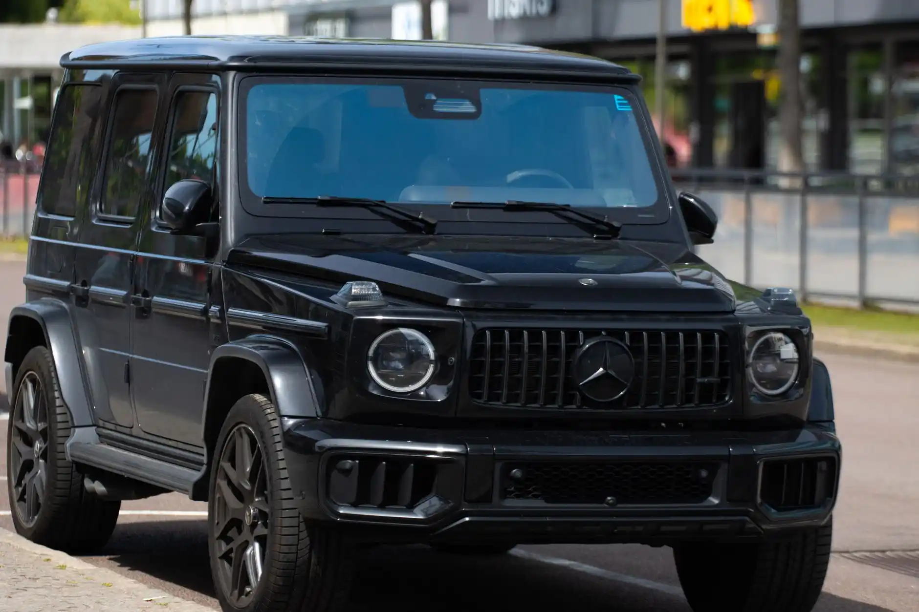 Black luxury SUV waiting at a designated SeaTac Airport pickup area at dusk, uniformed chauffeur opening the rear door while an airport greeter approaches with luggage