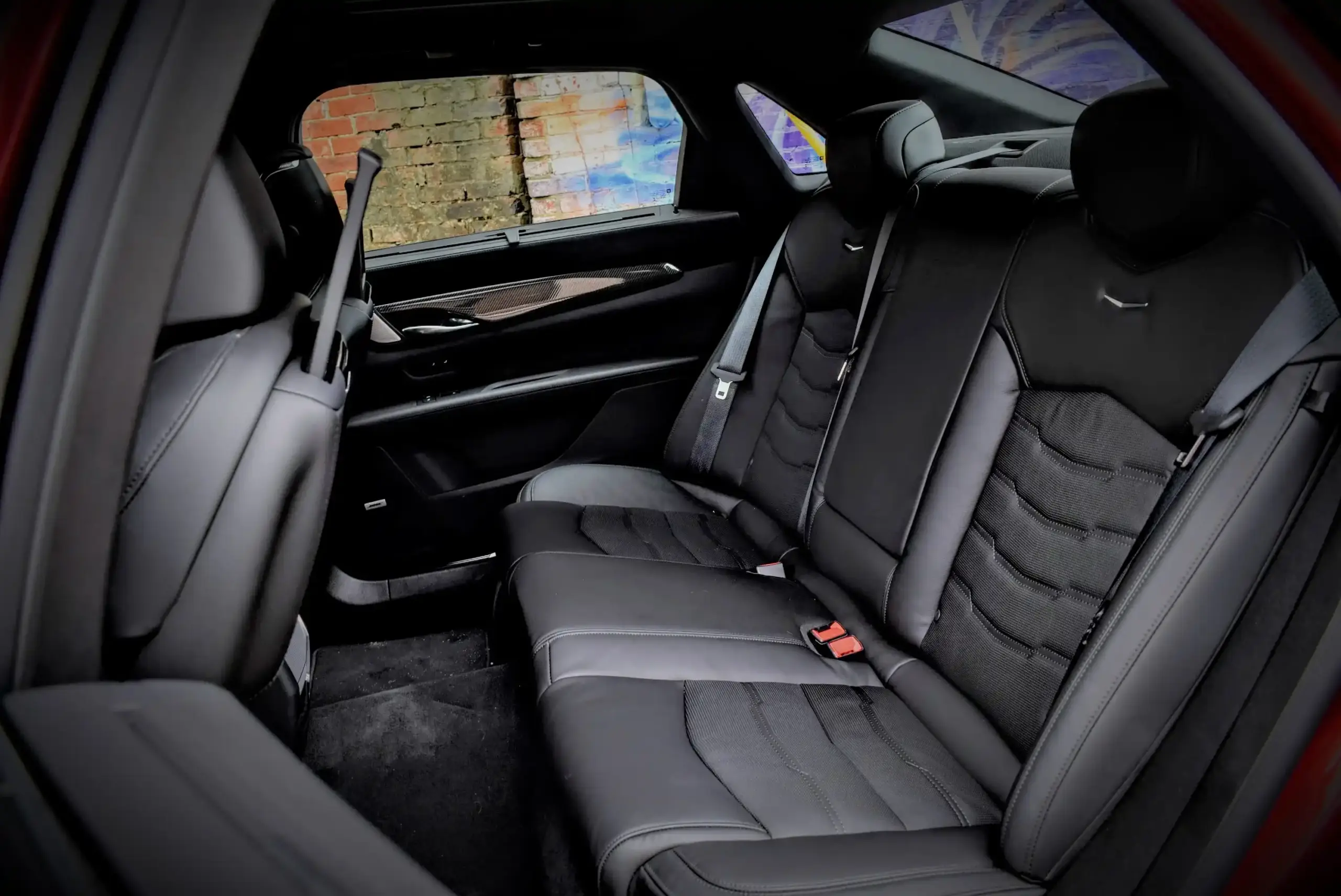 Black luxury SUV collecting travelers with ski bags outside Seattle-Tacoma International Airport, professional chauffeur loading luggage, overcast Pacific Northwest setting