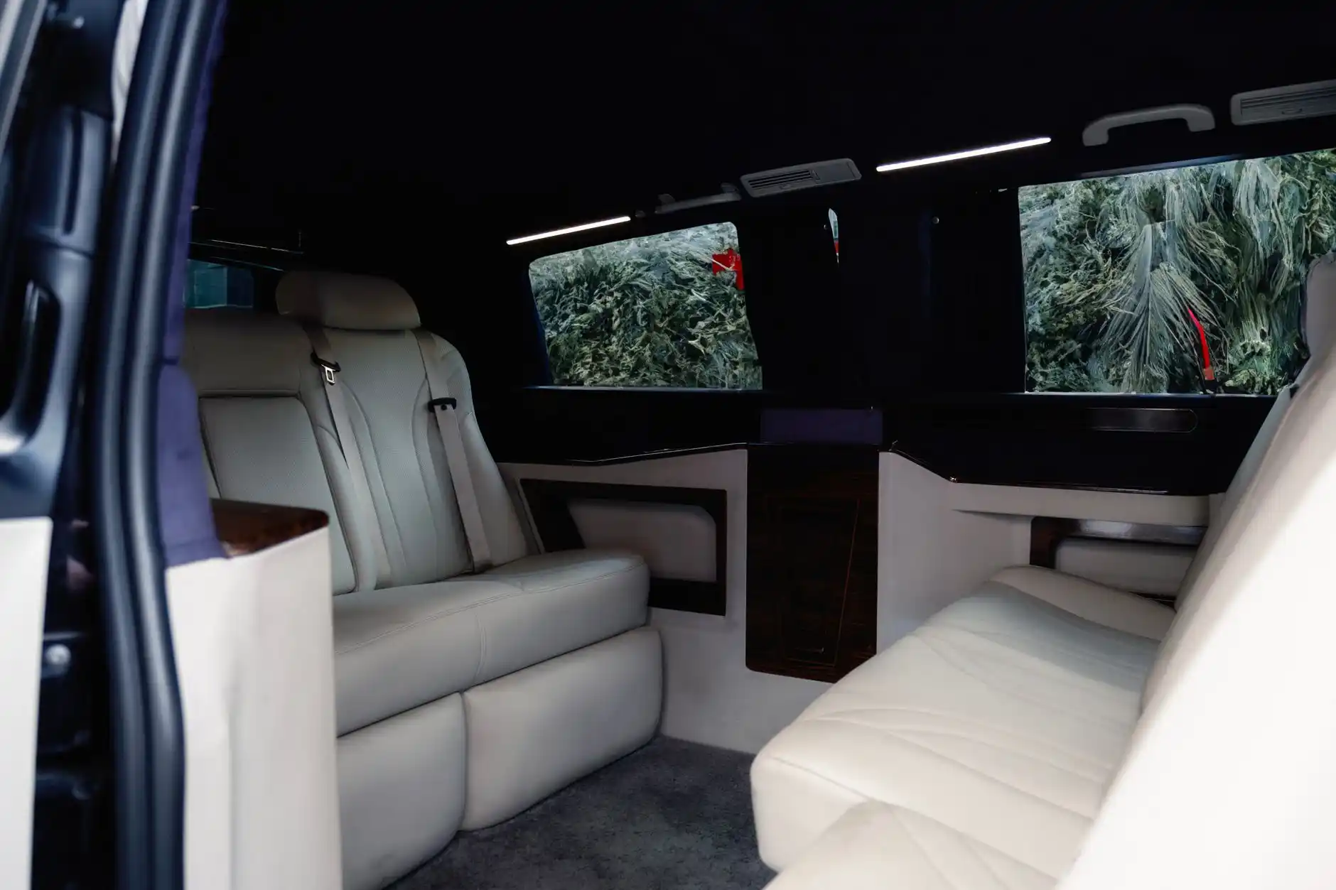 Interior lineup of a black executive sedan, premium SUV, and luxury passenger van at a Seattle private terminal, showing leather seating and organized luggage capacity